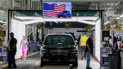 In this June 24, 2019, file photo, Ford employees work on a Lincoln Aviator line at Ford's Chicago Assembly Plant.
