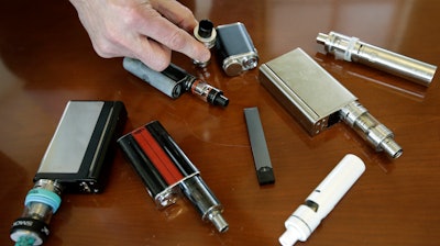 In this April 10, 2018, photo, Marshfield High School Principal Robert Keuther displays vaping devices confiscated from students in Marshfield, Mass.