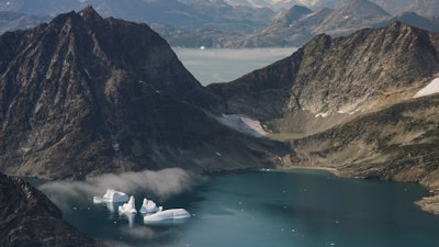 In this photo taken on Wednesday, Aug. 14, 2019, icebergs are photographed from the window of an airplane carrying NASA Scientists as they fly on a mission to track melting ice in eastern Greenland. Greenland has been melting faster in the last decade and this summer, it has seen two of the biggest melts on record since 2012.