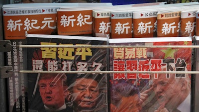 In this July 4, 2019, photo, Chinese magazines with front covers featuring Chinese President Xi Jinping and U.S. President Donald Trump on trade war are placed for sale at a roadside bookstand in Hong Kong.