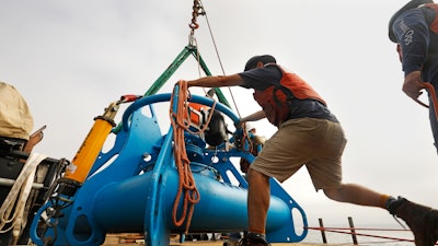 In this Aug. 8, 2019 photo, Jeff Pietro, a senior engineer assistant for Woods Hole Oceanographic Institute in Massachusetts, helps move the anchoring system for a microphone as it is into the Santa Barbara Channel.