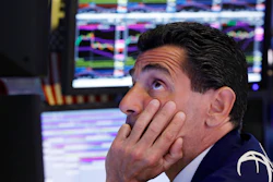 In this Aug. 12, 2019, photo, specialist Peter Mazza works at his post on the floor of the New York Stock Exchange.