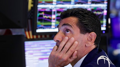 In this Aug. 12, 2019, photo, specialist Peter Mazza works at his post on the floor of the New York Stock Exchange.