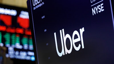 In this Aug. 9, 2019, file photo, the logo for Uber appears above a trading post on the floor of the New York Stock Exchange.