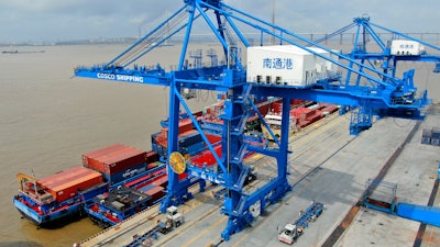 In this July 18, 2019, file photo, shipping containers are loaded onto a cargo ship at a port in Nantong, China.
