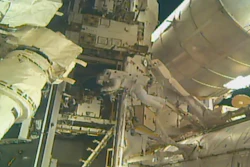This photo, provided by NASA, shows astronauts Andrew Morgan and Nick Hague (not seen) installing a docking port outside the International Space Station, Wednesday, Aug. 21, 2019.