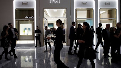 In this March 14, 2019, file photo, people attend the opening of a Piaget store during the opening night of The Shops & Restaurants at Hudson Yards in New York.