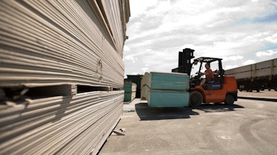 In this May 22, 2009, file photo, Michael Hilton uses a forklift to move sheets of Chinese-made drywall onto a flat bed truck at Venture Supply Inc. in Norfolk, Va.