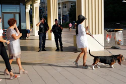 Tourists walk on the beach promenade as police officers stand guard ahead of the upcoming G7 Summit in Biarritz, France, Thursday, Aug. 22, 2019.