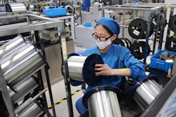 In this Aug. 14, 2019, photo, a woman works on a production line in a fiber optics factory in Nantong, China.