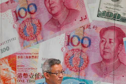 In this Aug. 6, 2019, file photo, a man walks by a money exchange shop in Hong Kong.