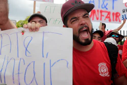 Members of the Communications Workers of America walk a picket line outside of an AT&T office Aug. 26, 2019, in Miami.