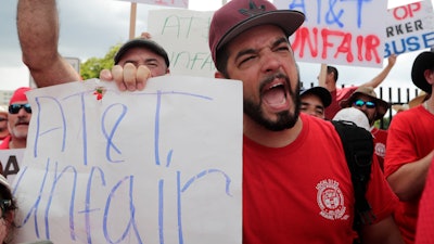 Members of the Communications Workers of America walk a picket line outside of an AT&T office Aug. 26, 2019, in Miami.