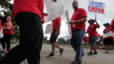 Members of the Communications Workers of America walk a picket line outside of an AT&T office, Monday, Aug. 26, 2019, in Miami.