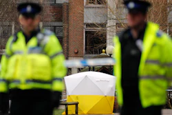 In this March 6, 2018 file photo, Police officers secure the area as a police tent covers the spot in Salisbury, England, where former Russian spy double agent Sergei Skripal and his daughter, Yulia, were found critically ill following exposure to a nerve agent. President Donald Trump is levying more sanctions on Russia in connection with the alleged 2018 poisoning of former Russian spy Sergei Skripal and his daughter, Yulia, in Salisbury, England.