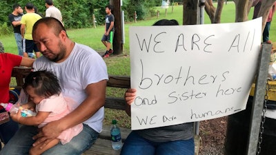 Workers from PH Foods and their supporters gather at a protest on Tuesday, Aug. 13, 2019 in Morton, Miss., after workers from the chicken processing plant said they were fired. Workers say the plant fired the majority of remaining workers days after federal agents arrested 99 people there for immigration violations.