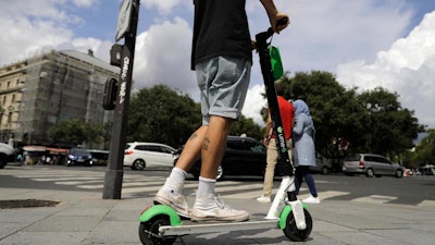 A man rides an electric scooter in Paris, Monday, Aug. 12, 2019.