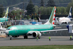 In this Wednesday, May 8, 2019 file photo, workers stand near a Boeing 737 MAX 8 jetliner being built for American Airlines prior to a test flight in Renton, Wash. Federal safety officials are recruiting pilots from airlines around the world to test changes that Boeing is making in flight-control software on the grounded 737 Max jet, according to two people briefed on the situation.