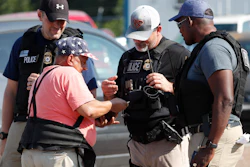 Domingo Candelaria, a registered immigrant, shows federal agents his identification as he prepares to leave the Koch Foods Inc., plant in Morton, Miss., following a raid by U.S. immigration officials, Wednesday, Aug. 7, 2019. The raid, one of several in Mississippi, was part of a large-scale operation targeting owners as well as undocumented employees.