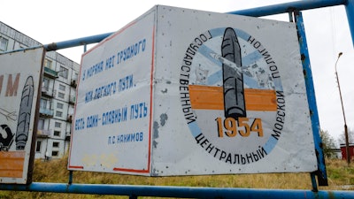 This photo taken on Oct. 7, 2018, shows a billboard that reads 'The State Central Navy Testing Range' near residential buildings in the village of Nyonoksa, northwestern Russia. The Aug. 8, 2019, explosion of a rocket engine at the Russian navy's testing range just outside Nyonoksa led to a brief spike in radiation levels and raised new questions about prospective Russian weapons.