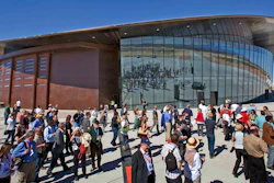 In this Oct. 17, 2011 file photo, guests stand outside the new Spaceport America hangar in Upham, N.M. Virgin Galactic is scheduled to unveil the interior of its digs at Spaceport America, providing the first glimpse of mission control, a prep area for pilots and where paying customers will lounge ahead of their suborbital flights. Company officials are gathering Thursday, Aug. 15, 2019, at the remote facility in the New Mexico desert to show off two levels of the custom-tailored hangar at the taxpayer-financed spaceport.