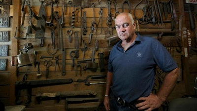 In this Monday, July 22, 2019, photo, Ted Schuster poses for a photo at Prairie Forge in Hopkinton, Iowa. Shuster, now 56, has operated a blacksmithing operation, Prairie Forge, in eastern Iowa for three decades. The small-scale business is a far cry from the big-city environment its owner once considered.