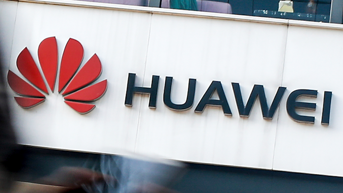 In this July 30, 2019, file photo a woman walks by a Huawei retail store in Beijing. Chinese tech giant Huawei has accused U.S. authorities of trying to coerce employees to gather information on the company and of trying to break into its information systems. The company, the target of U.S. accusations that it is a security threat, said Wednesday, Sept. 4, that American officials were using 'unscrupulous means' to disrupt its business.