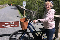 In this June 8, 2019, file photo, Janice Goodwin stands by her electric-assist bicycle at a gate in Acadia National Park, Maine.