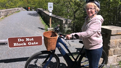 In this June 8, 2019, file photo, Janice Goodwin stands by her electric-assist bicycle at a gate in Acadia National Park, Maine.
