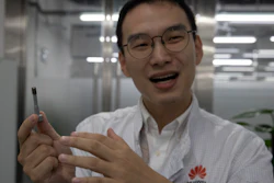 In this Aug. 21, 2019, photo, a Huawei research engineer holds up a coated screw, designed to reduce signal interference, at the Huawei Materials lab in Dongguan, China.