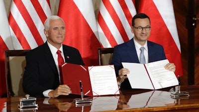 Vice President Mike Pence and Polish Prime Minister Mateusz Morawiecki display an agreement they signed in Warsaw, Sept. 2, 2019.
