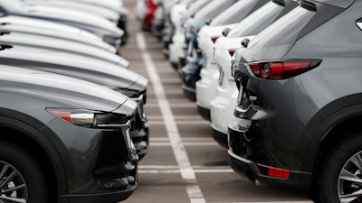 In this Sunday, May 19, 2019, file photo, lines of unsold vehicles sit at a dealership in Littleton, Colo.