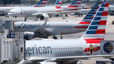 In this April 24, 2019, photo, American Airlines aircraft parked at their gates at Miami International Airport.