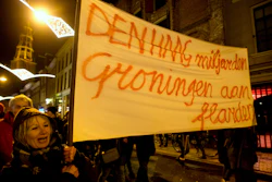 In this Jan. 19, 2018, file photo, a protester holds a banner reading 'The Hague Billions, Groningen To Shreds' as thousands of people protest against gas extraction and related earthquakes.