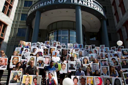 Demonstrators hold pictures of the plane crash victims during a vigil outside of the Department of Transportation in Washington, Tuesday, Sept. 10, 2019.