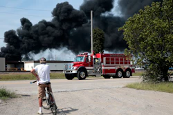 A resident watches as a firetruck arrives in downtown Dupo, Ill. to help fight a tanker fire, Tuesday, Sept. 10. 2019.