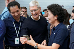 Apple CEO Tim Cook, center, looks at the the new iPhone 11 Pro Max during an event to announce new products Tuesday, Sept. 10, 2019, in Cupertino, Calif.