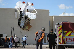 Police and fire personnel look on as workers remove a single-engine plane after it crashed into the terminal building at the Ak-Chin Regional Airport, Tuesday, Sept. 10, 2019, in Maricopa, Ariz.