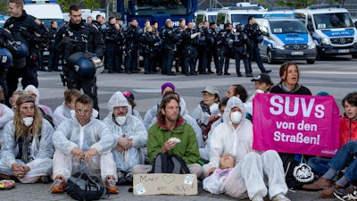 Activists block the main entrance of the fairground in Frankfurt, Sunday, Sept. 15, 2019.