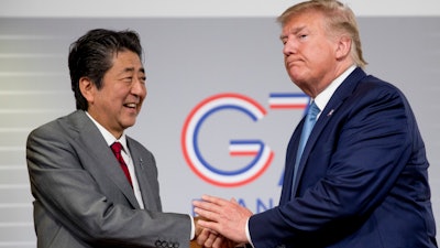 In this Aug. 25, 2019, file photo, President Donald Trump and Japanese Prime Minister Shinzo Abe shake hands following a news conference at the G-7 summit in Biarritz, France.