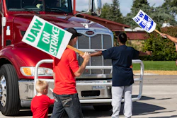 Picketing union members stand off with a semi-truck attempting to enter the GM Davison Road Processing Center, Sept. 17, 2019 in Burton, Mich.
