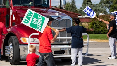 Picketing union members stand off with a semi-truck attempting to enter the GM Davison Road Processing Center, Sept. 17, 2019 in Burton, Mich.
