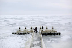 In this image taken Feb. 9, 2012, tourists admire the frozen IJsselmeer inland sea on Afsluitdijk, a dike closing off the Wadden sea and North Sea from IJsselmeer inland sea, northern Netherlands.