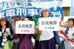 A group shows banners reading 'unjust sentence' in front of Tokyo District Court, Thursday, Sept. 19, 2019.