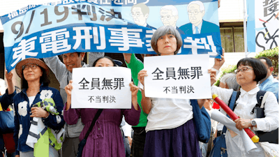 A group shows banners reading 'unjust sentence' in front of Tokyo District Court, Thursday, Sept. 19, 2019.