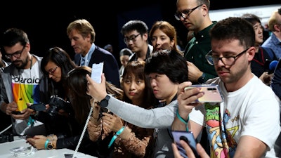 Visitors take pictures of new Huawei devices during an event in Munich, Thursday, Sept. 19, 2019.