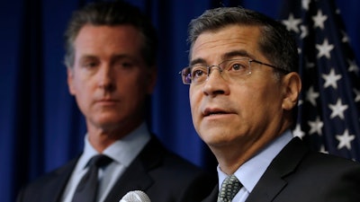 In this Sept. 18, 2019, file photo California Attorney General Xavier Becerra, right, flanked by Gov. Gavin Newsom, discusses the Trump administration's pledge to revoke California's authority to set vehicle emissions standards.