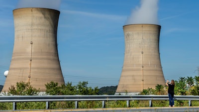 Eileen DeFrancisco of Middletown, Pa., shoots a video of Three Mile Island minutes before the power plant was shut down, Friday, Sept. 20, 2019.