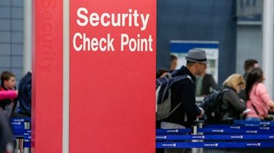 In this March 22, 2016 file photo, passengers check into their flights near a security checkpoint sign at O'Hare International Airport in Chicago.