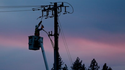 In this Nov. 26, 2018, file photo, a Pacific Gas & Electric lineman works to repair a power line in fire-ravaged Paradise, Calif.